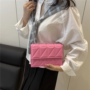 Pink quilted shoulder bag with silver chain strap shown in a stylish crossbody wear