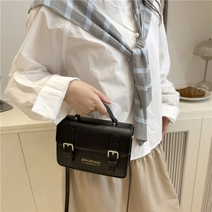 Elegant black crossbody mini bag with double buckle decor and golden lettering detail