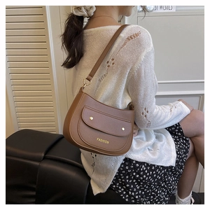 Detail of a brown lychee textured shoulder bag with golden rivets and fashion logo