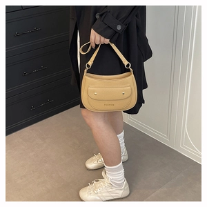 Detail of hobo shoulder bag with magnetic flap pocket and gold hardware in camel brown