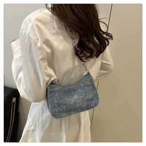 Vue détaillée du sac baguette en tweed bleu clair avec bandoulière chaîne argentée
