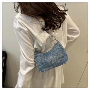 Sac sous le bras en tweed bleu clair avec chaîne argentée vue de dos sur un mannequin
