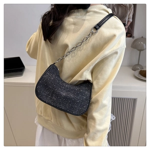 Détail du sac sous le bras en denim gris foncé avec clous argentés et bandoulière
