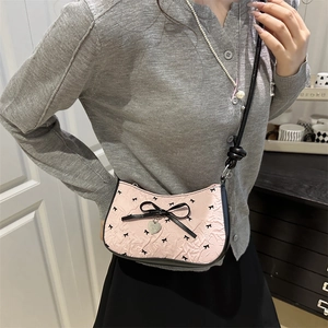 Sac croissant rose avec nœuds noirs, texture plissée et pendentif en cœur