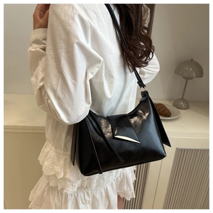 Sac sous le bras minimaliste en cuir noir brillant avec triangle en métal sur robe