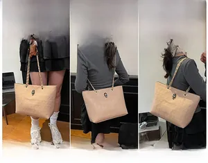 Detail view of beige tote with skull embossing, metal ornament and chain strap