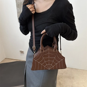 Brown leather handbag with white spider web stitching and adjustable shoulder strap