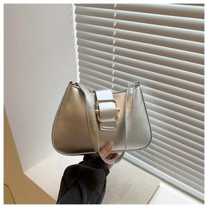 Close-up of minimalist silver crossbody bag with a large decorative square buckle detail