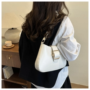 Detail of minimalist white shoulder bag with a large polished gold metal buckle