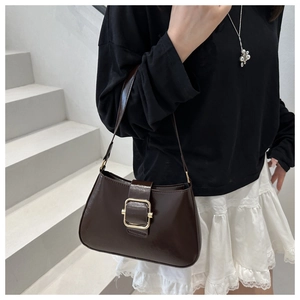 Close-up of a dark brown glossy leather baguette bag with a golden square buckle detail