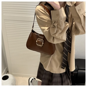 Detail view of a vintage dark brown shoulder bag with a large gold square buckle lock