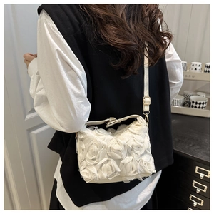Detailed macro view of 3D chiffon rose flowers and adjustable strap on a white bag