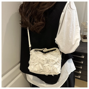 Detail of white 3D floral evening bag with fabric roses and gold chain on shoulder
