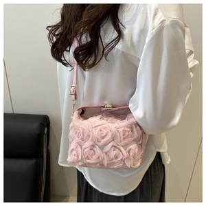 Détail du sac seau rose porté en bandoulière avec des fleurs 3D romantiques