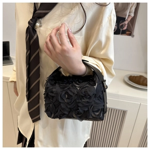 Gros plan du sac noir avec textures de roses 3D et finitions en métal doré élégant