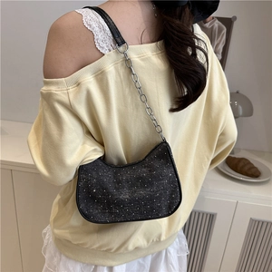 Sac hobo noir scintillant en denim avec chaîne argentée porté par un mannequin