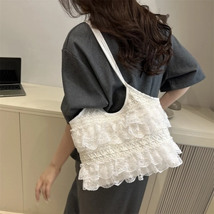 White lace tote bag with tiered ruffles and delicate embroidery for summer vacations