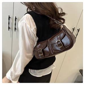 Détail du sac baguette vintage marron foncé avec fini brillant et boucles argentées