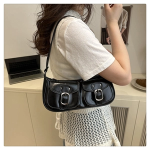 Vue latérale d'une femme portant un sac vintage en cuir brillant noir à boucles