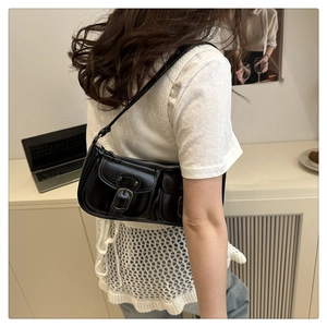 Détail du sac baguette vintage noir avec deux poches et des boucles argentées