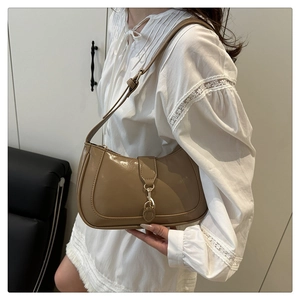 Detail of khaki leather shoulder bag featuring adjustable strap and gold metal hook