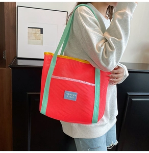 Detail of dopamine color mesh tote bag with vibrant pink mesh and mint green strap