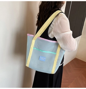 Detailed view of lightweight mesh beach bag with vibrant blue and yellow contrast straps