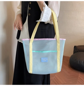 Detail view of large mesh tote bag showing pastel color-blocking and logo patch