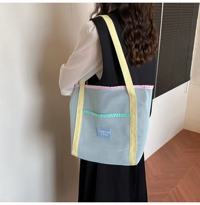 Detail of colorful mesh beach tote bag featuring sky blue mesh and yellow handles