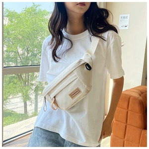 Beige waterproof nylon crossbody bag shown worn on a model for a casual travel look