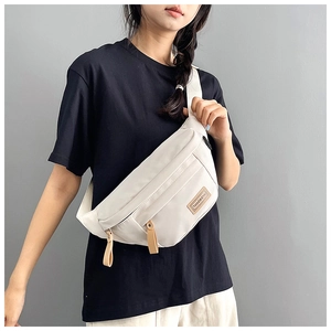 Detail of adjustable strap and brown leather puller on waterproof nylon crossbody bag
