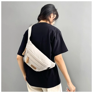 Detail view of water-resistant nylon crossbody bag with multi-zippered compartments