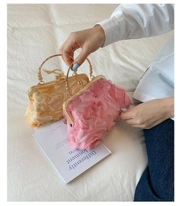 Detail of pink and yellow evening bags with 3D chiffon floral petals and gold handles
