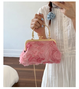 Macro detail of pink floral evening bag with metal ring handle and 3D fabric petals