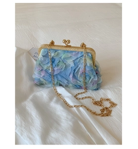 Macro detail of gradient petal texture and gold vintage metal clasp on a chain bag