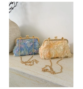 Detailed shot of 3D floral evening bags with gradient petals and metal chain straps