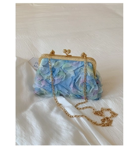 Detailed view of 3D lace floral applique and vintage metal clasp on a blue chain bag