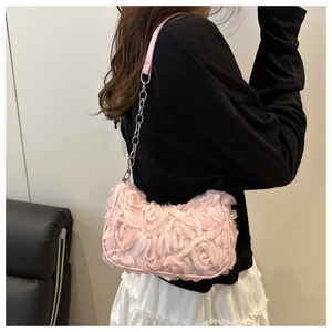 Detail einer rosa 3D-Blumen-Handtasche mit silberner Kette an einem Modell