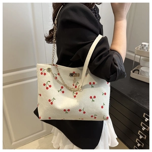 Détail du sac cabas en velours côtelé blanc avec imprimés cerises et chaîne dorée