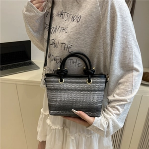 Mini hand-woven striped bucket bag in black and grey gradient with golden rings