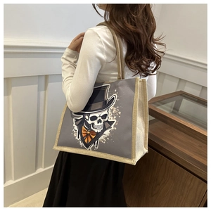 Detail of the large gray tote bag with skull print and natural canvas woven handles