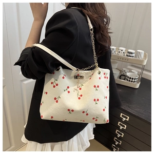 Détail du sac fourre-tout en velours côtelé écru avec imprimé cerise et pendentif cerf