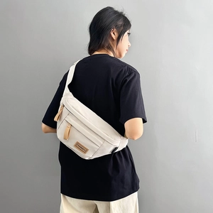 Minimalist beige sports saddle bag with crossbody strap and multi-pocket design