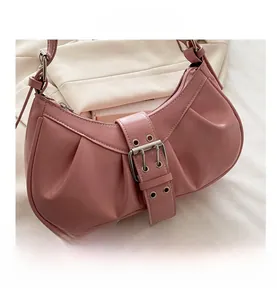 Detail view of pink pleated crescent bag featuring wide silver buckle strap and glossy finish