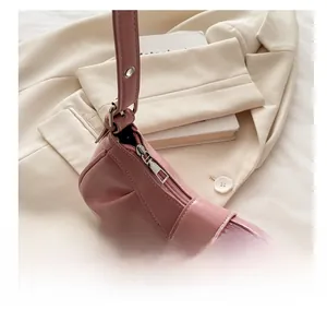 Close-up of smooth metal zipper and buckle detail on a pink pleated shoulder bag