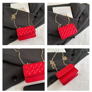 Macro shot of red quilted mini crossbody bag with gold chain and flap closure detail