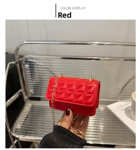 Detail of red quilted mini chain bag with gold shoulder strap and leather texture