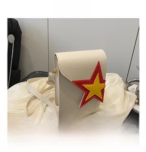Vue détaillée du sac bandoulière en similicuir crème avec patch en étoile coloré