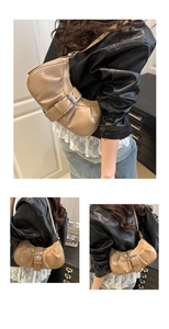 Detail of khaki pleated underarm bag with glossy finish and adjustable metal buckle strap