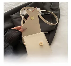 Détail du sac crème minimaliste avec rabat en forme d'étoile et doublure intérieure rouge